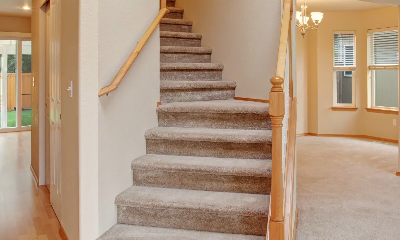 A stairway ascending to a hallway with a closed door at the end
